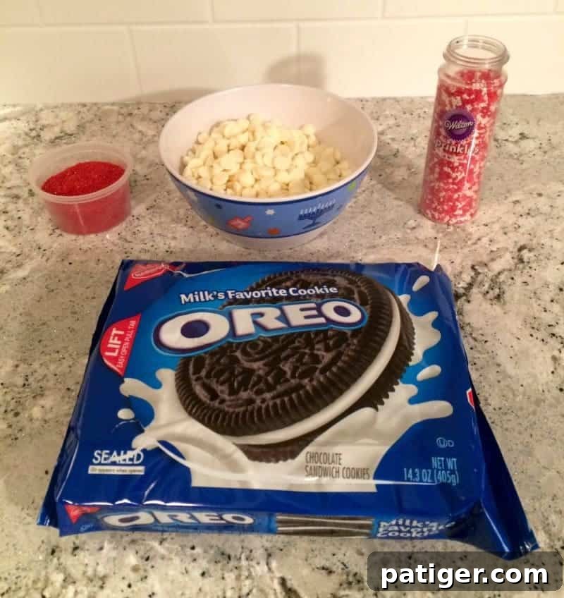 Love-Dipped White Chocolate Oreos 3 Oreo Cookie package, sprinkles, and white chocolate chips ingredients for white chocolate covered Oreos.