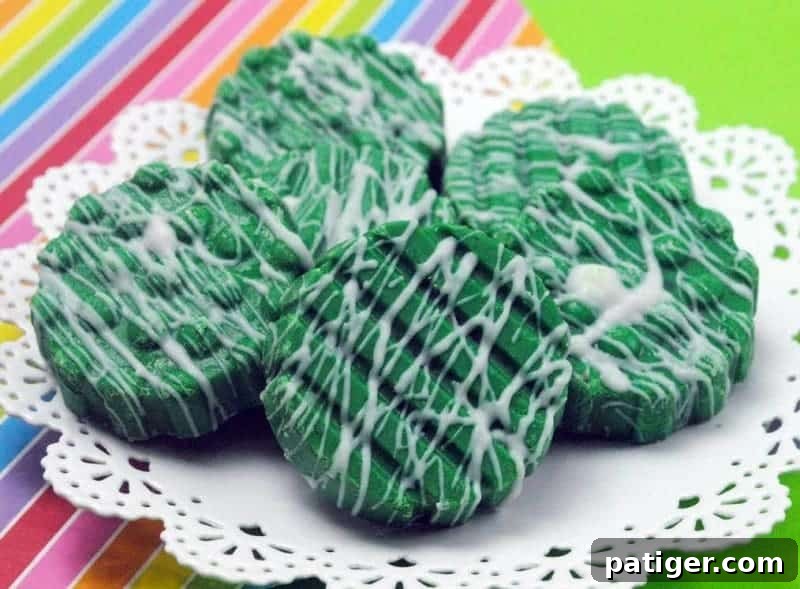 Close-up of St. Patrick's Day Oreos covered in glossy green chocolate with delicate white drizzles, showcasing the festive detail.