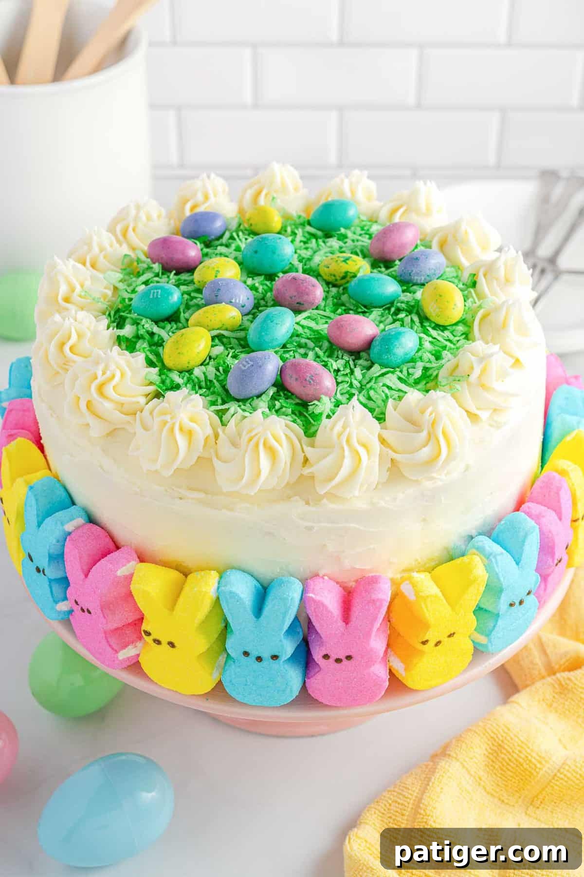 Easter Layer Cake decorated with marshmallow peeps, shredded coconut, and candy eggs.