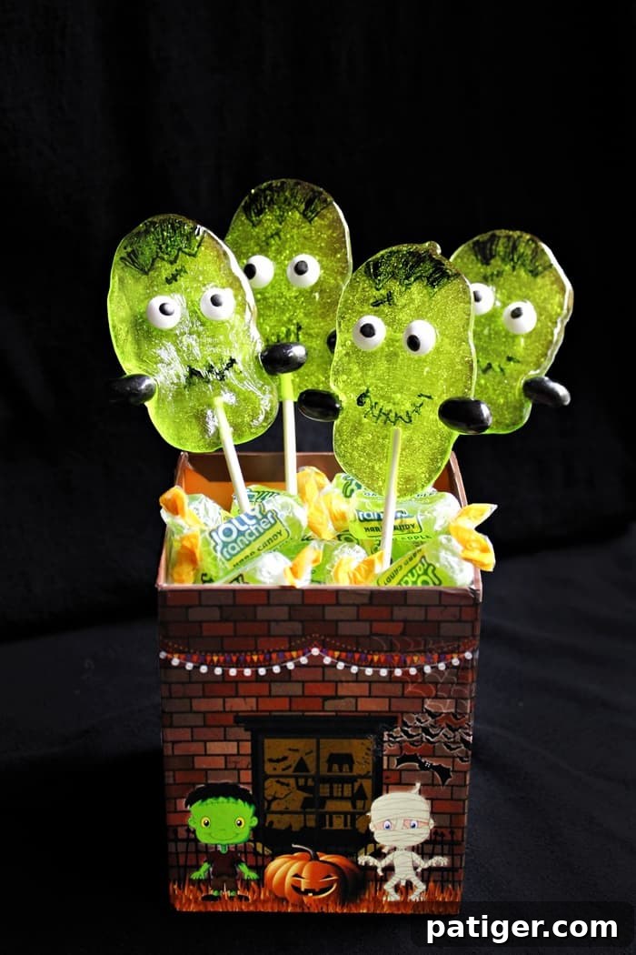 Delightful Frankenstein Suckers made with vibrant Green Apple Jolly Ranchers, perfect for an easy Halloween party treat.