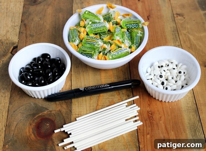 Essential ingredients and supplies for crafting Frankenstein Suckers, featuring Jolly Ranchers and candy eyes.