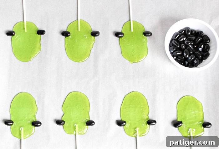 Quickly attach black licorice jelly beans to the sides of the melted candy to form Frankenstein's iconic bolts.