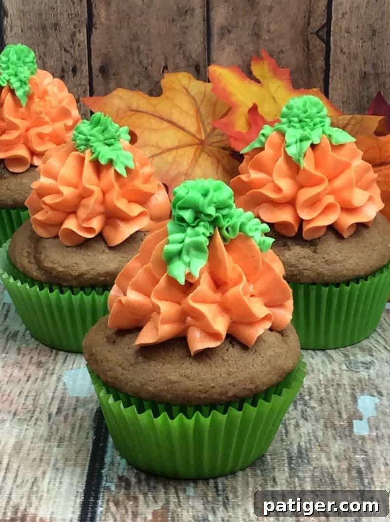 Pumpkin spice doughnuts topped ith orange and green icing to look like pumpkins.