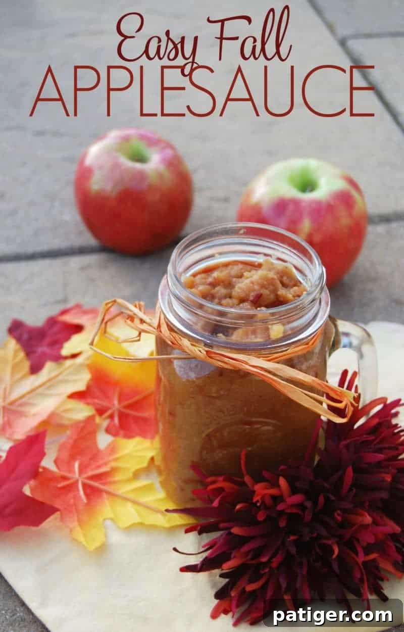 Easy Fall Applesauce Recipe Pin. Homemade applesauce in a glass jar, surrounded by fresh apples and fall leaves.