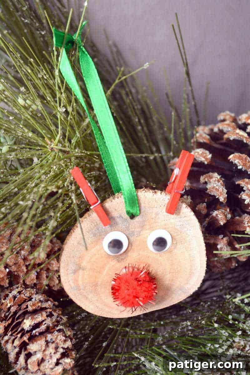 Rustic Rudolph the Red-Nosed Reindeer ornament crafted from a wood slice, perfect for a cozy Christmas tree.