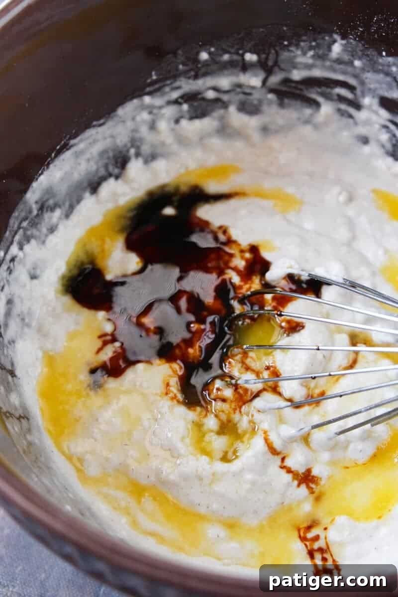 A wire whisk combining dry ingredients in a bowl, demonstrating the initial step for gingerbread pancake batter.