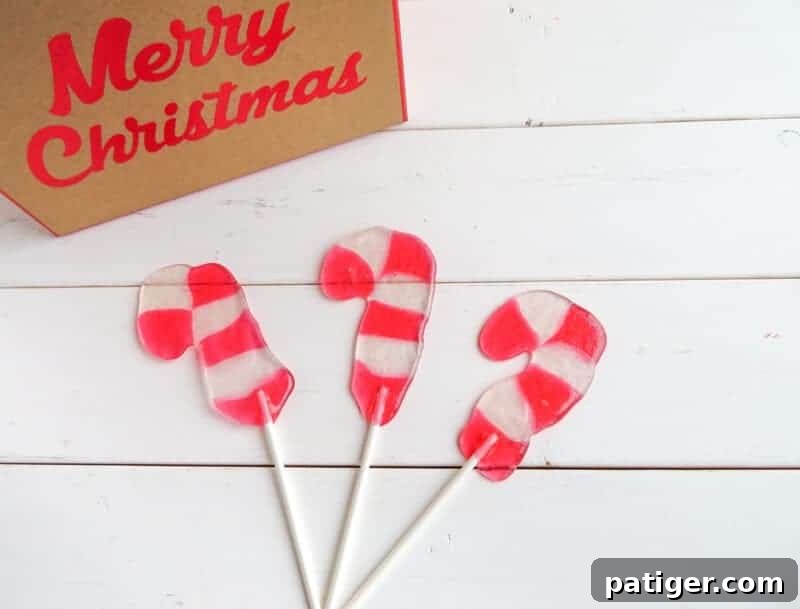 Multiple vibrant Candy Cane Lollipops displayed on a clean white wooden background, showcasing their festive appeal.