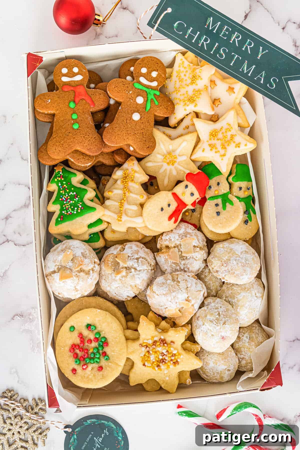 Gingerbread men, sugar cookies, shortbread, and snowballs elegantly boxed for a delightful Christmas cookie exchange.