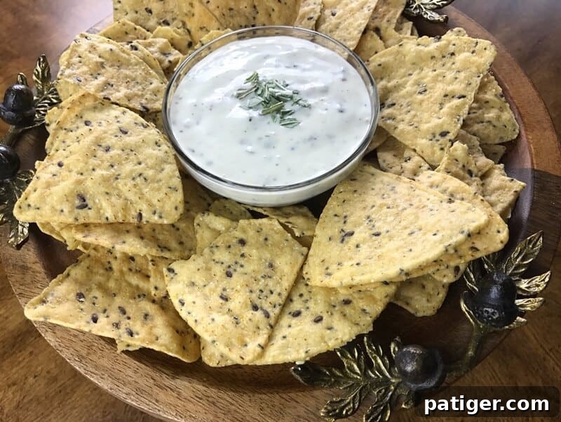 A close-up of a perfectly prepared bowl of creamy bacon ranch dip, elegantly garnished with finely chopped fresh basil, highlighting its inviting texture and readiness to be served as a delightful appetizer.