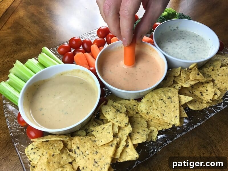 A hand gracefully dipping a fresh baby carrot into a rich, creamy, and inviting dip, highlighting the perfect texture and delicious nature of the appetizer, inviting viewers to take a bite.