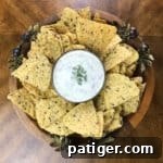 Round platter with dip in center surrounded by tortilla chips.
