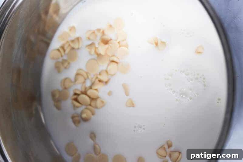 Milk and white chocolate chips in a pot being warmed.