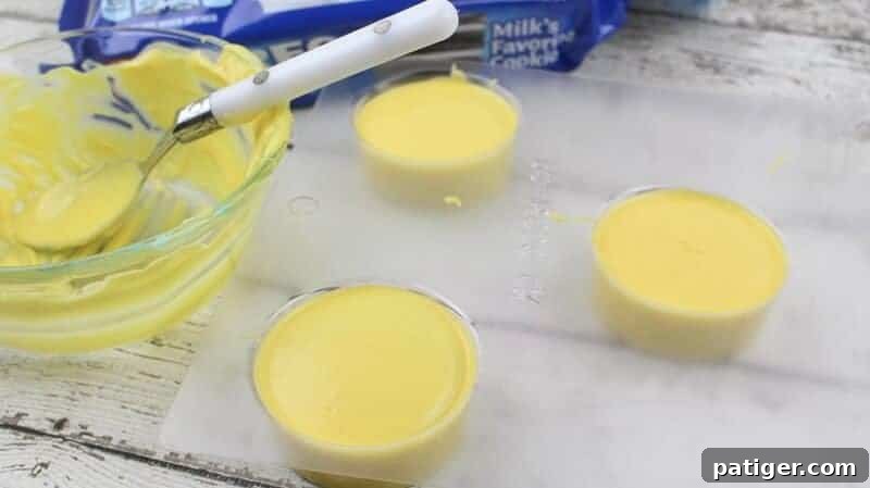 Yellow melted candy covering each oreo in mold, smoothed over.