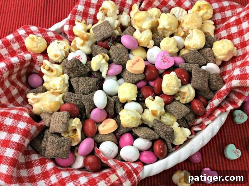 Sweet Valentine Medley 3 Valentine's Day snack mix with popcorn, conversation heart candies, M&M's, and homemade cherry muddy buddies.