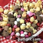 Valentine's Day snack mix made with cherry muddy buddies, popcorn, and candies.