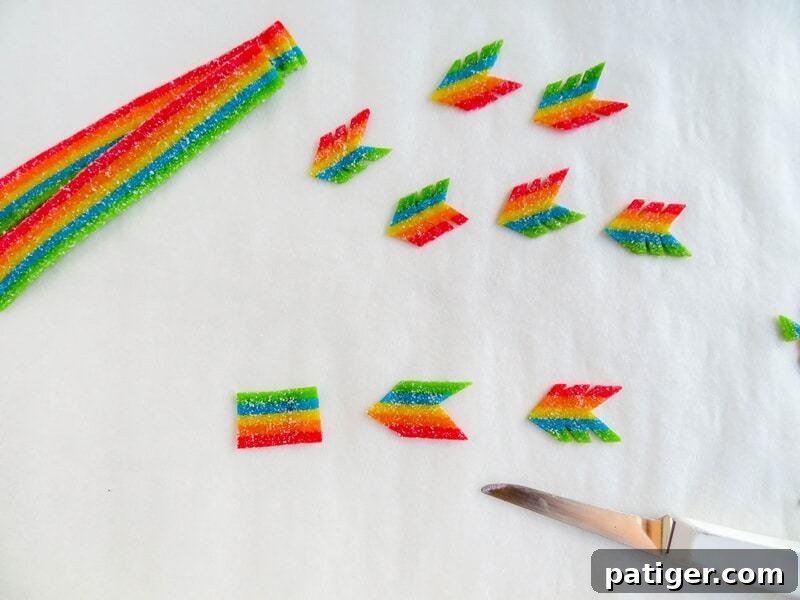 Rainbow candy being cut into the shape of feather at end of arrow.