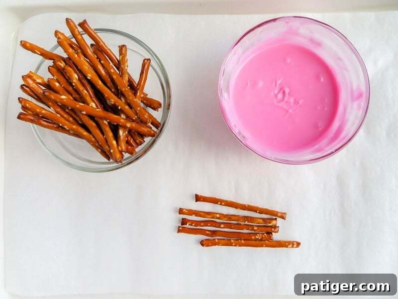 Pretzel sticks and melted pink candy.