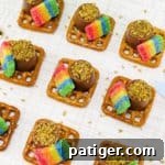St. Patrick's Day pretzel bites made from square pretzels topped with rolo candies, gold sprinkles, and rainbow airheads.