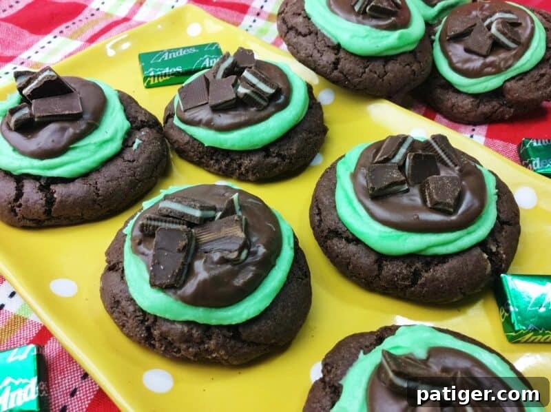 Chocolate cookies topped with minty green frosting, chocolate, and pieces of Andes Mint candies.