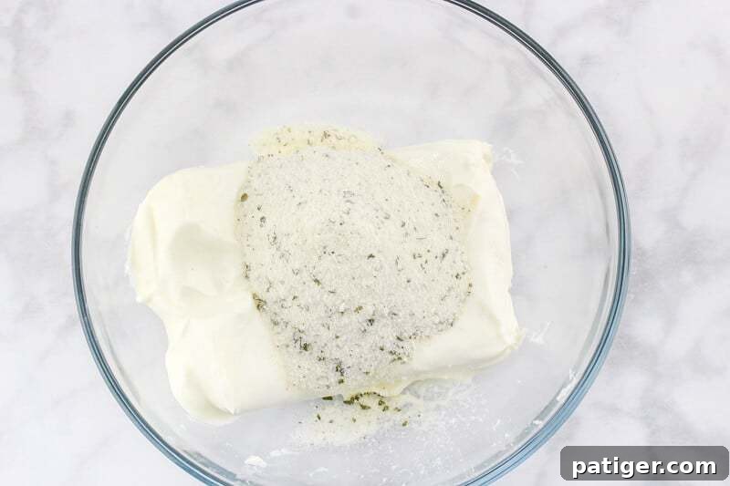 A bowl containing cream cheese and ranch seasoning, perfectly mixed into a smooth, savory spread.