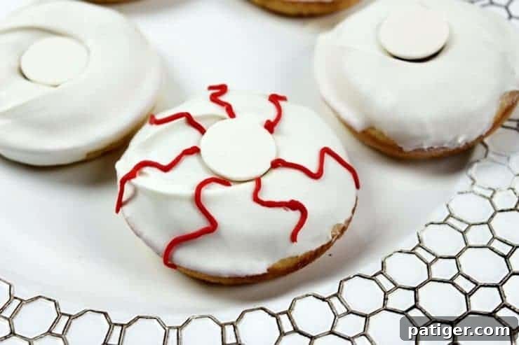 Red squiggly lines of icing drawn on donut to look like bloodshot eyes, adding creepy details.