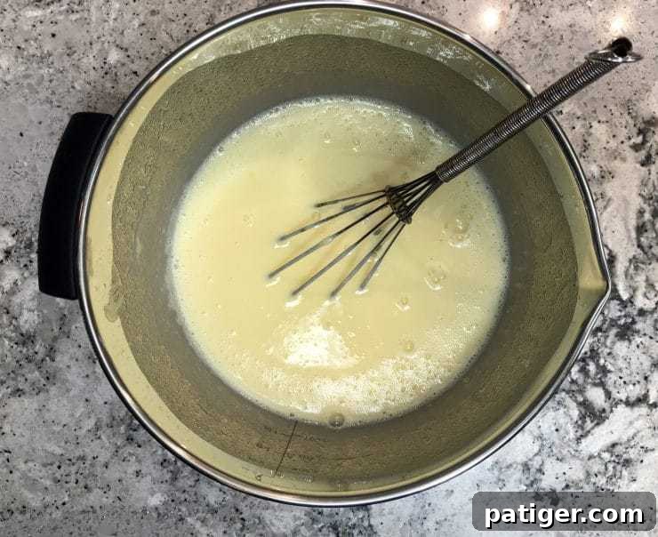 Vanilla Wafer Banana Pudding Cupcakes 4 A large, clear glass bowl brimming with freshly prepared, thick, and creamy banana pudding, perfectly smooth and ready for the next step.