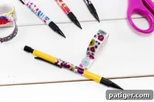 A hand demonstrates wrapping a yellow mechanical pencil with patterned washi tape, showing the smooth overlapping technique.