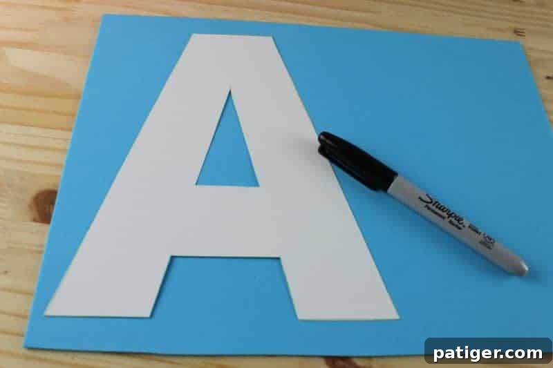 A is for Anchor: Printable Letter A Craft Fun 5 A child tracing the letter A template onto a yellow piece of craft foam, a key step in developing fine motor skills for the A for Anchor craft.