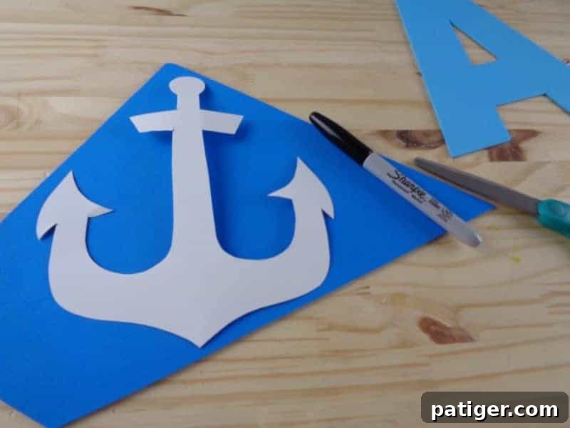 A is for Anchor: Printable Letter A Craft Fun 7 Cutting out the anchor template from paper and tracing it onto dark blue craft foam for the Letter A craft, focusing on precision.