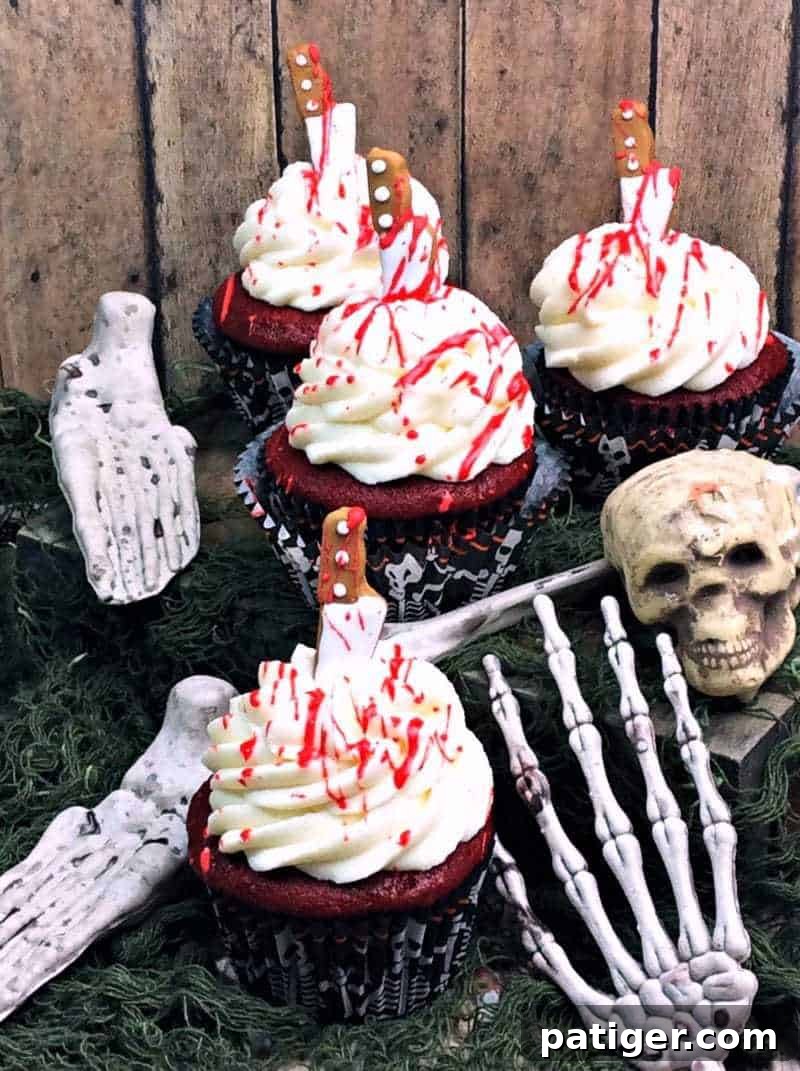 Crimson Confections 4 Bloody red velvet cupcakes surrounded by spooky Halloween decorations.