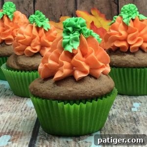 A perfectly baked pumpkin spice cupcake adorned with a beautifully piped buttercream pumpkin design, ready to be devoured.