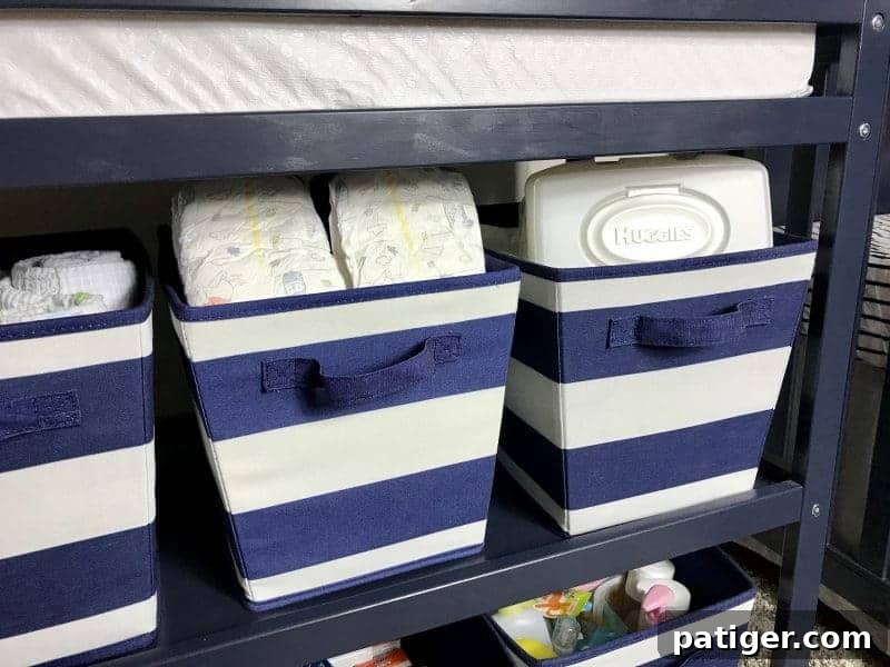 Blue and white striped storage bins with diapers and wipes.