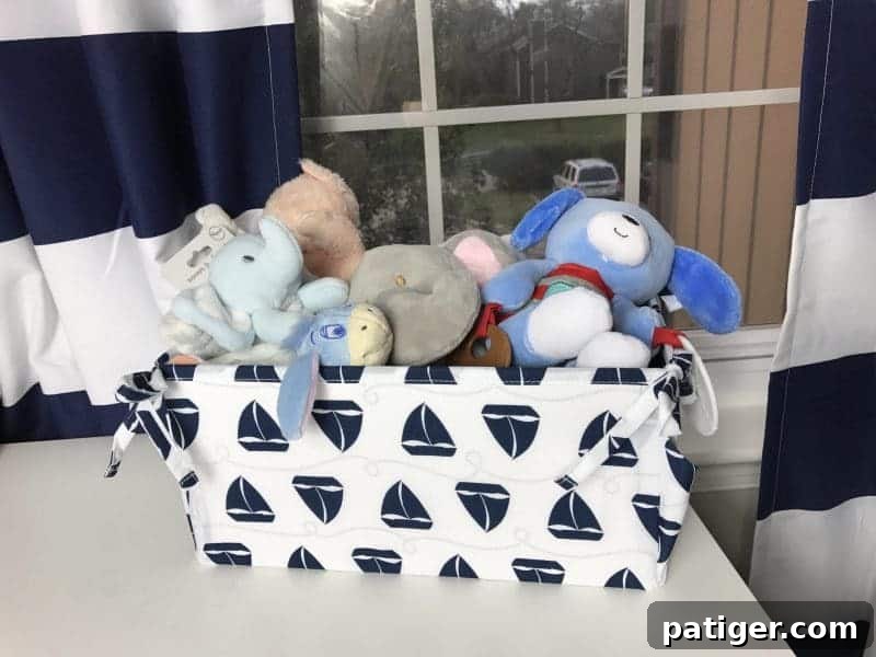 Sailboat patterned storage bin with stuffed animals on dresser.