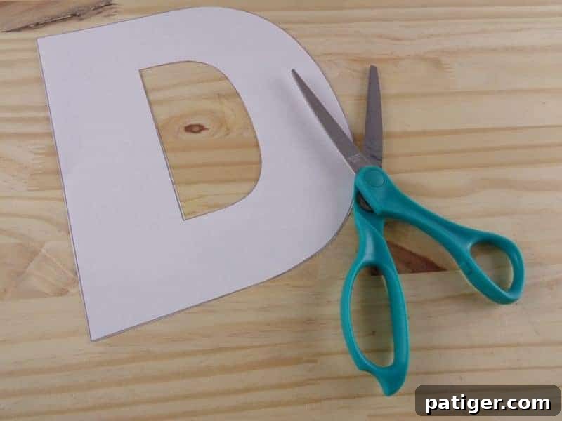 Fun Letter D Dog Craft Printable 4 Step 1: Cut out the Letter D template from paper for the dog craft.