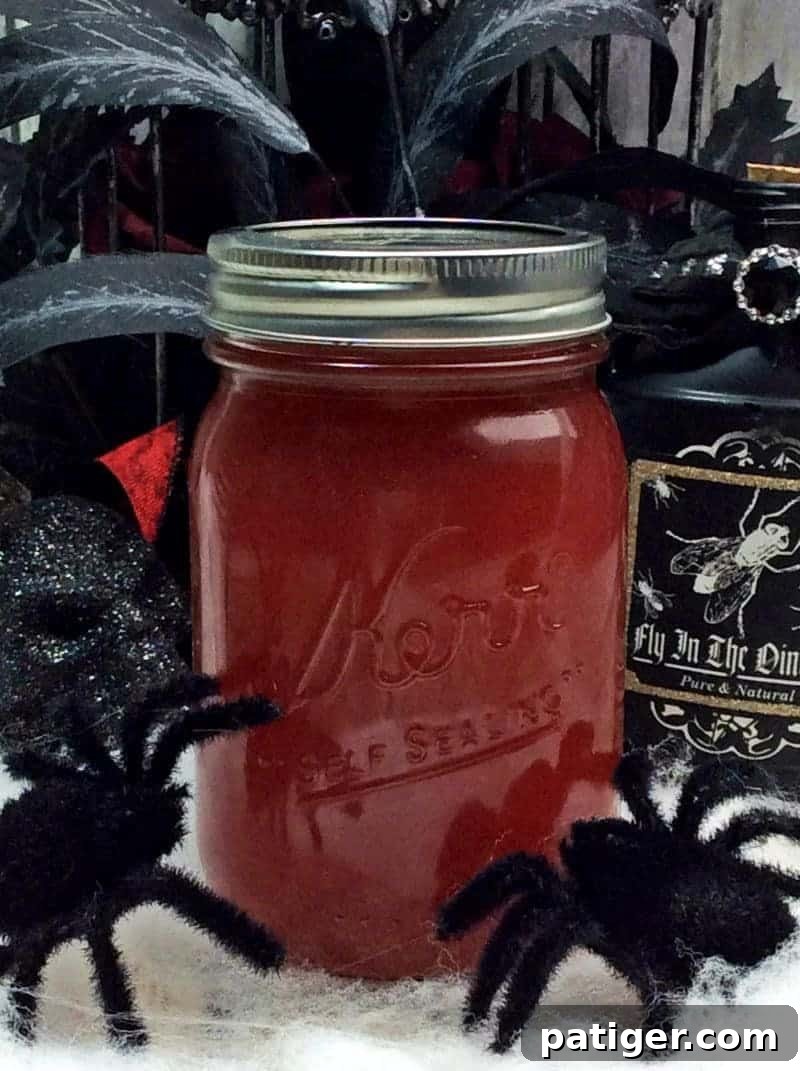 Black widow venom moonshine in a sealed mason jar surrounded by Halloween decorations.