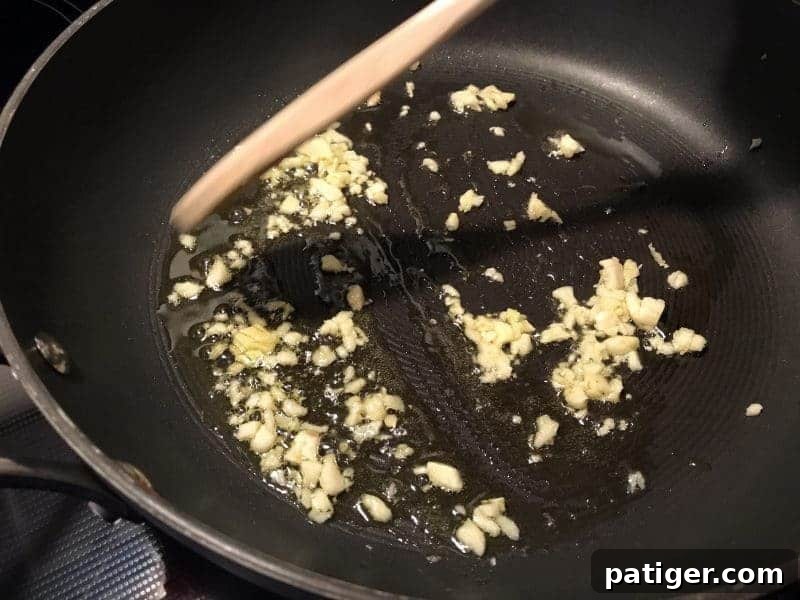 Garlic Soy Seared Asparagus 5 minced fresh garlic in oil in frying pan.