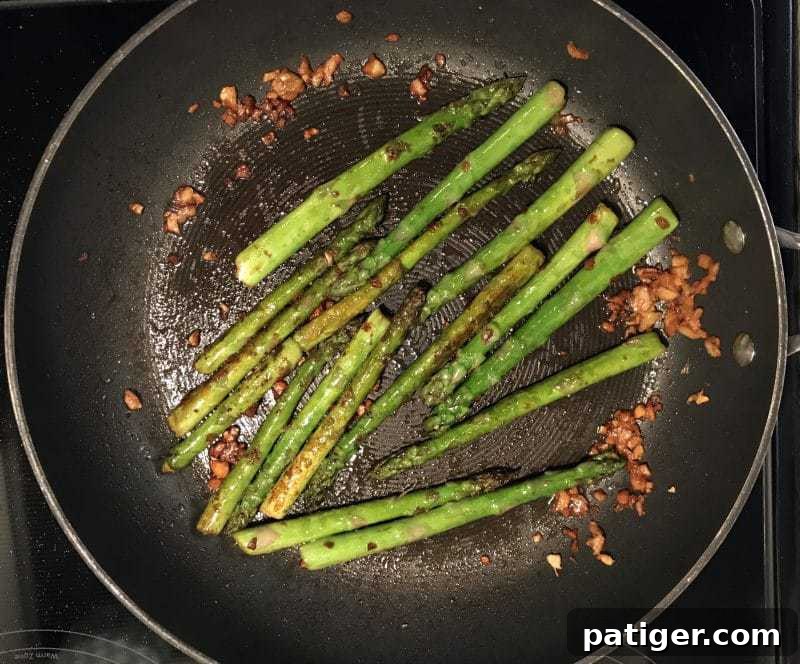 Garlic Soy Seared Asparagus 7 Asparagus with garlic in frying pan.