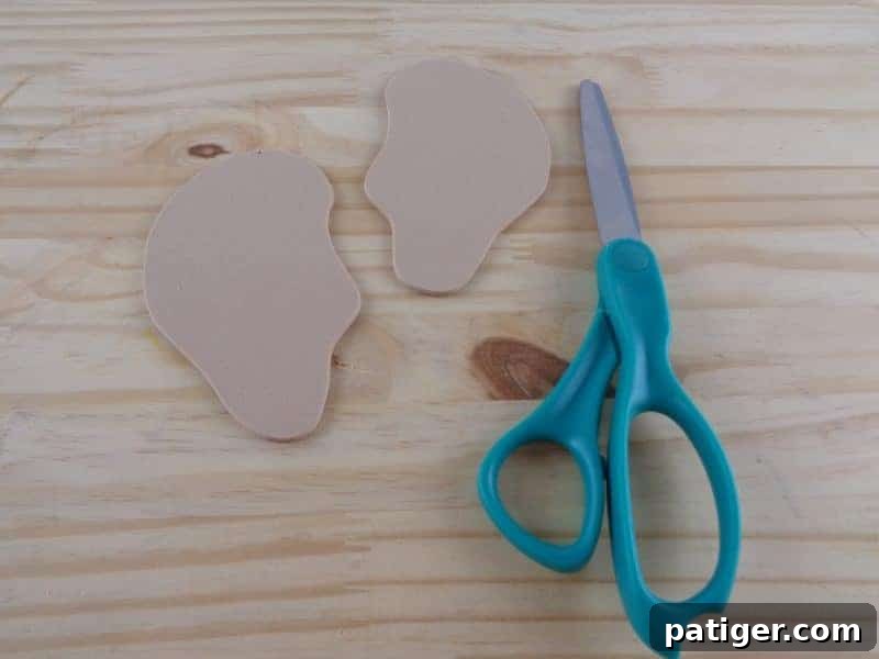 A hand tracing the ear template onto craft foam, showing how to get two ear shapes before cutting them out.