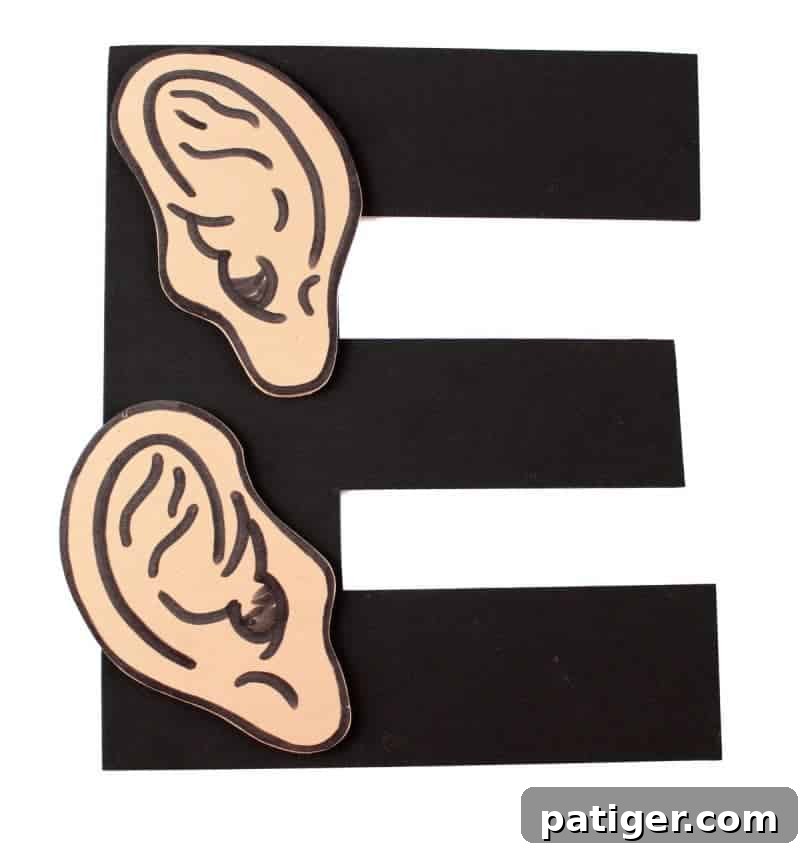 The completed Letter E craft, shaped like the letter E with two ears attached, part of a preschool 'Letter of the Week' series.