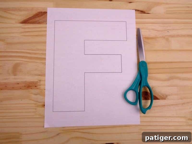 Carefully cutting out the letter F from the printable template to begin our preschool letter craft.