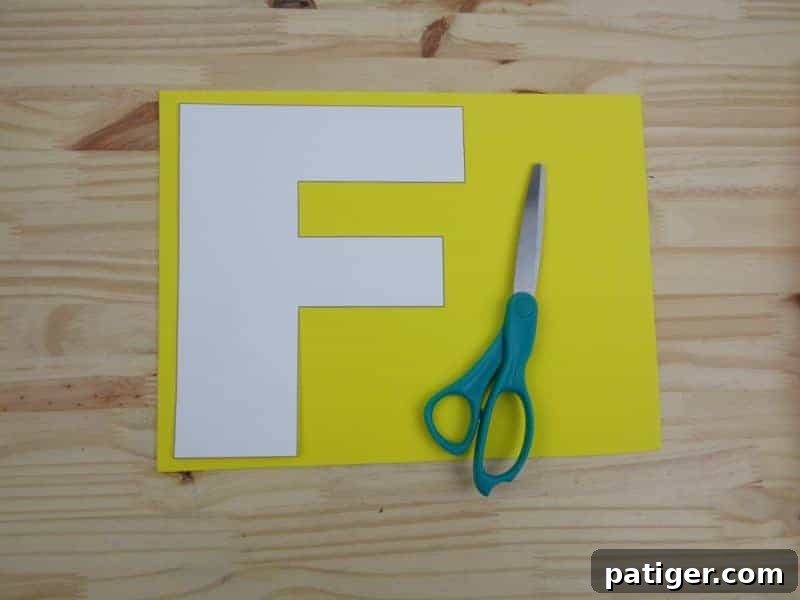 Tracing the bold letter F outline onto craft foam for our F is for Fire preschool activity.