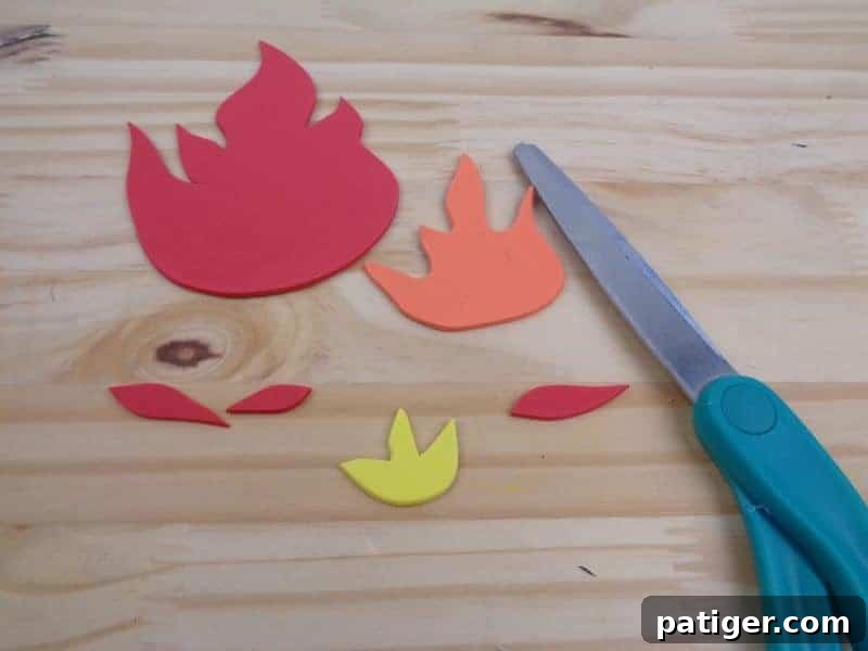 Tracing and cutting the fire template pieces from craft foam in vibrant colors for our Letter F craft.