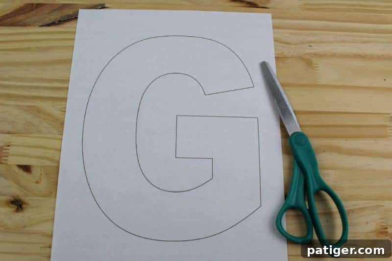 First step: Carefully cut out the letter G shape from the printed template, preparing it for tracing onto craft foam and ensuring clear lines.