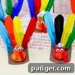 A group of colorful turkey crafts made from Hershey’s Kisses with feathers and googly eyes.