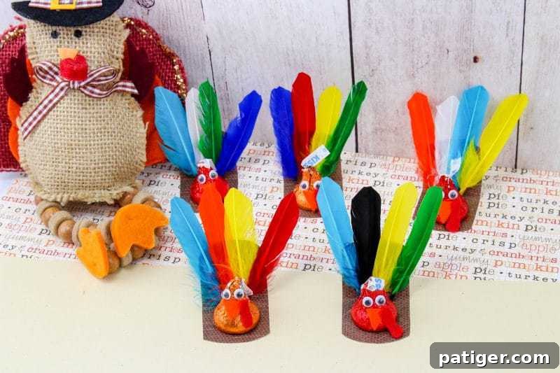 DIY Thanksgiving Chocolate Kiss Turkeys 3 Several Hershey’s Kisses turkey crafts are lined up in front of a rustic burlap turkey decoration. Each mini turkey features colorful feathers, googly eyes, and is placed on a brown base over themed background paper.