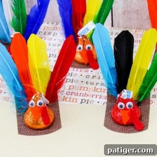 A group of colorful turkey crafts made from Hershey’s Kisses with feathers and googly eyes.