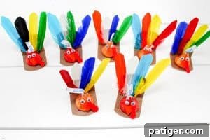 A group of colorful turkey crafts made from Hershey’s Kisses with feathers and googly eyes.