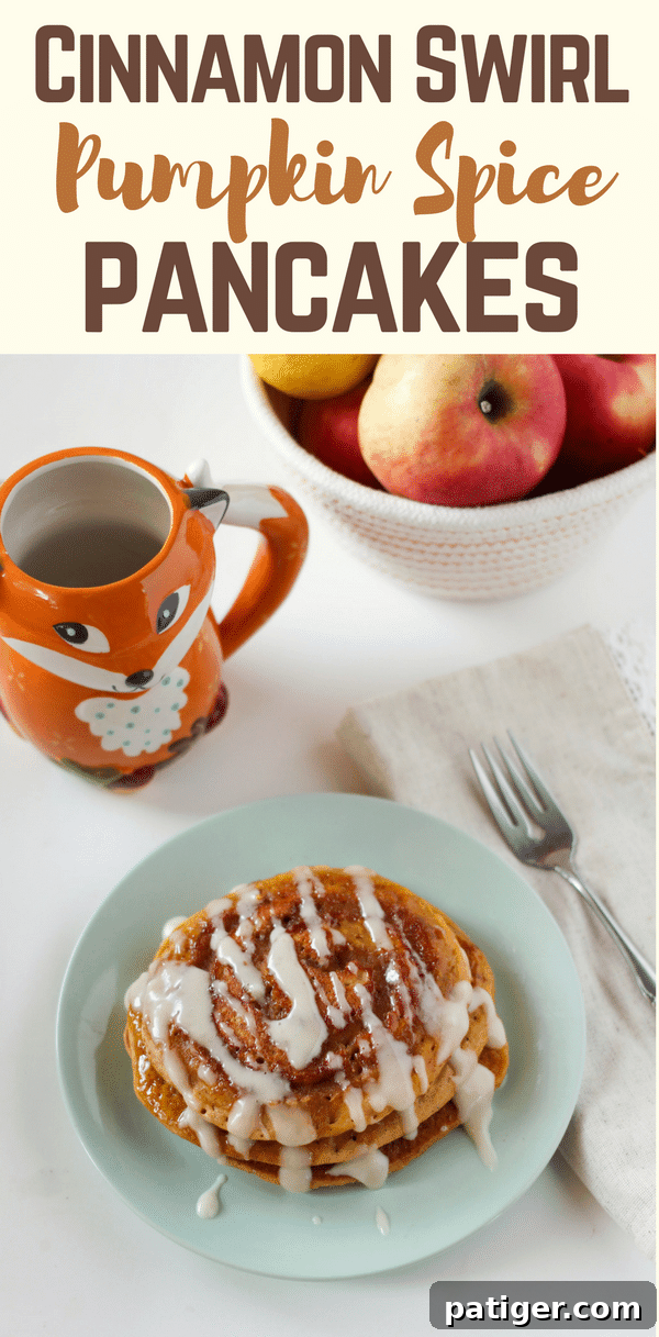 Close-up of fluffy cinnamon swirl pumpkin spice pancakes with melted cream cheese glaze, garnished with cinnamon