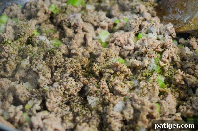 Ground turkey and vegetables cooking in a pan for turkey and stuffing balls.