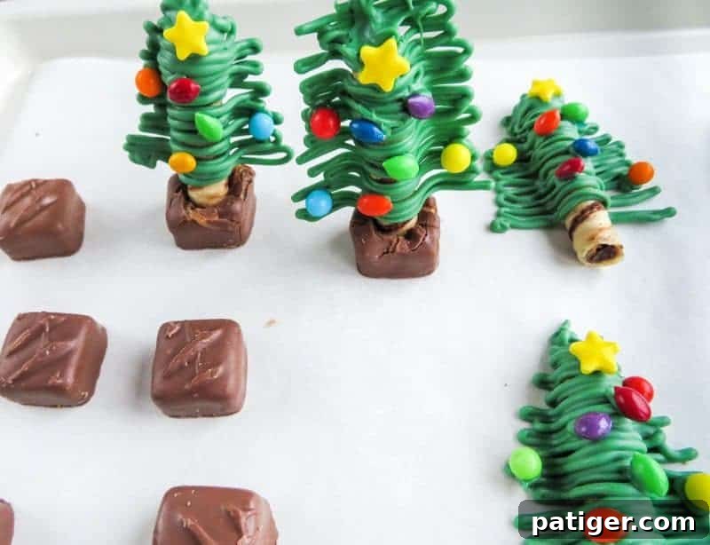 Attaching softened Milky Way Miniatures as bases to the Christmas tree treats.